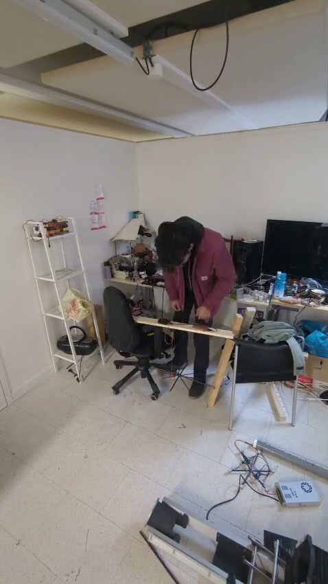 Working with planks in the studio, building a makeshift structure to hang a servo motor. Jugaad: solving a problem with what is in front of you.